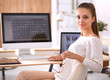 © shefkate - Young woman working in office, sitting at desk
