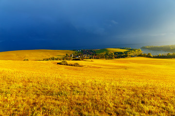 Beautiful landscape, green and yellow meadow and lake with mountain in background. Slovakia, Central Europe.