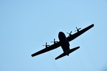 Silhouette Of Hercules Transport Plane Against The Blue Sky