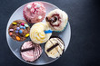 © marcin jucha - Vibrant cupcakes on plate on dark background