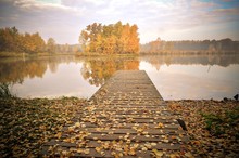 Autumn Morning Landscape. Wooden Pier And Autumn Trees On The Lake.