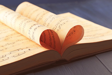 Sticker - Book pages curved into heart shape on table close up