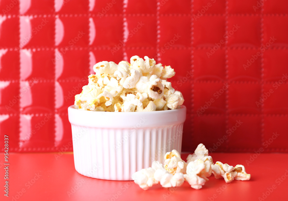 Salted popcorn on red background