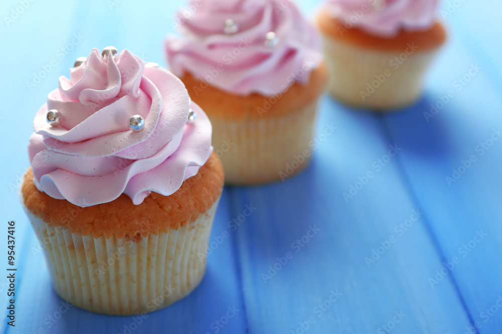 Tasty cupcakes on color wooden background