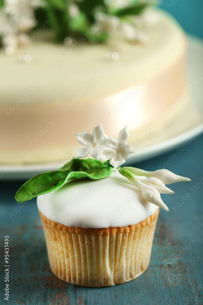 Tasty cupcake and cake, on table, on color background