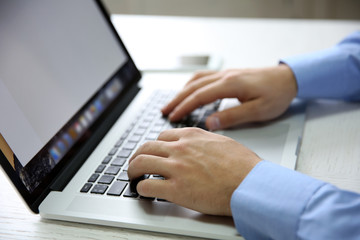 Wall Mural - Young businessman using his laptop, close up