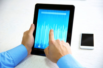 Poster - Young businessman using his tablet-pc, close up