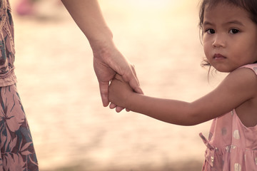 child cute little girl and mother holding hand together