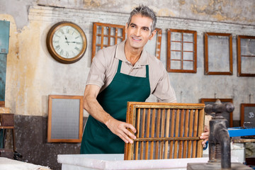 Wall Mural - Worker Dipping Mold In Pulp And Water While Looking Away