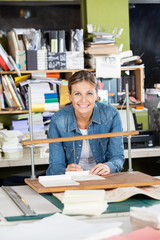 Wall Mural - Happy Woman Binding Papers At Workbench