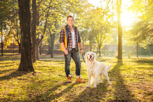 Man Standing In A Meadow And Posing With A Dog