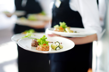 Waiter carrying plates with meat dish