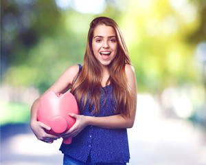 Wall Mural - young cute woman with a big piggy bank