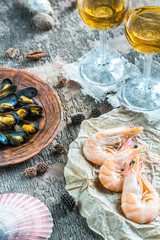 Wall Mural - Seafood with two glasses of white wine on the wooden table