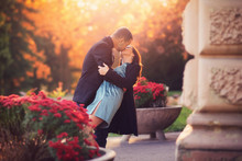 Attractive Couple Have A Romantic Date In A Castle Garden, Sunset In The Background