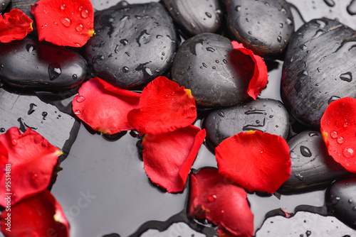 Fototapeta na wymiar Red rose petals and therapy stones 