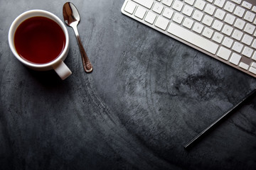 Office table with, computer and tea cup. View from above with copy space