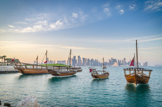 Wall Mural - Dhows moored off Museum Park in central Doha, Qatar, Arabia, with some of the buildings from the city's commercial port in the background.