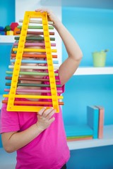 Wall Mural - Smiling girl holding a xylophone