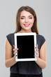 © Drobot Dean - Smiling woman showing blank tablet computer screen