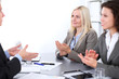© rogerphoto - A group of business people applauding at meeting  on the background of office. Focus on a beautiful blonde