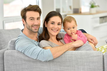 Wall Mural - Couple with baby girl enjoying family time at home