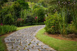 Stone path on a green garden with flowers