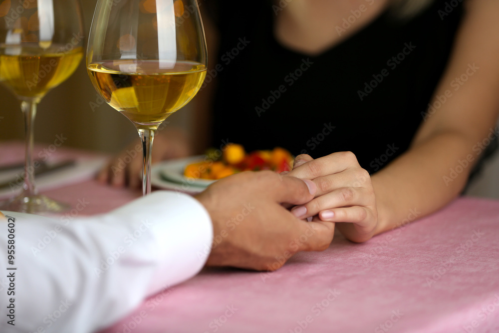 Elegant couple holding hands in the restaurant