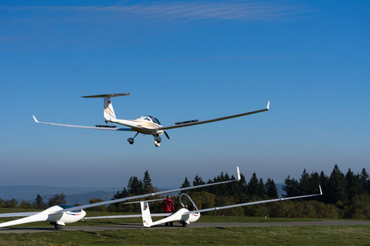 landung kleinflugzeug auf der wasserkuppe mit wartenden segelflieger