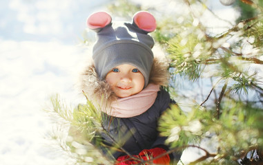 Happy smiling child near christmas tree in winter day