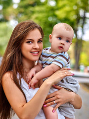 Happy loving mother and her baby outdoors.