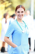 © Africa Studio - Attractive woman doctor standing against unfocused group of medics, outdoors