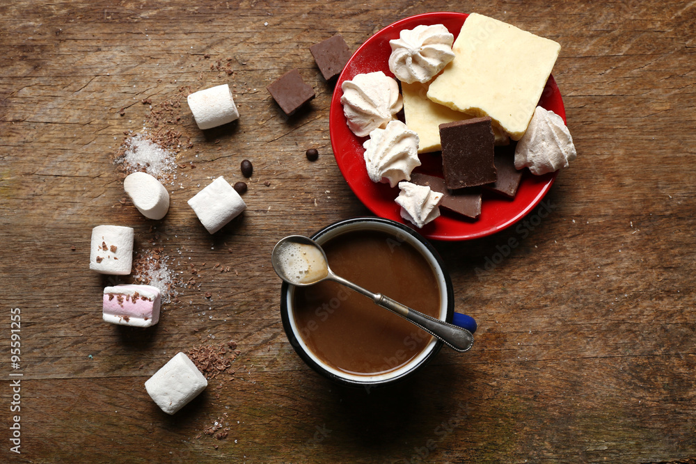 Cup of coffee with sweets on wooden background