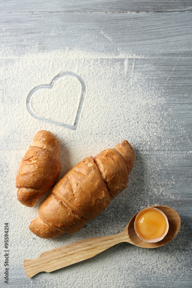 Hearts of flour and rolling pin on light background
