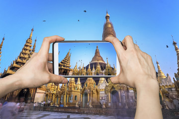 Girl taking pictures on mobile smart phone in Shwedagon Pagoda ,