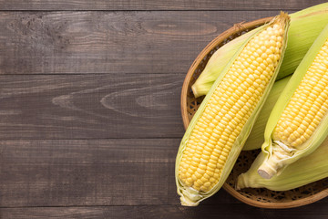 Fresh organic yellow sweet corn on wooden table. Top view