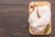 Raw chicken leg on cutting board on wooden background