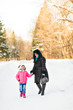 © satura_ - Mother and daughter holding their hands outdoors in winter