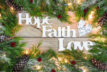 Hope, Faith, Love Sign With Christmas Tree Garland And Lights Border