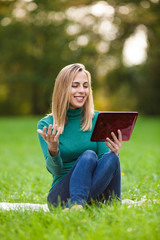 Wall Mural - Young woman is chatting with her friend in park