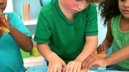 Wall Mural - Kids playing together with modelling clay on a table