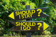 Should I Stay? Should I Go? Signpost With Forest Background