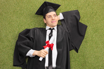 Canvas Print - Graduate lying on grass and daydreaming