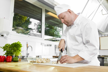 Wall Mural - Professional chef preparing vegetables in large kitchen