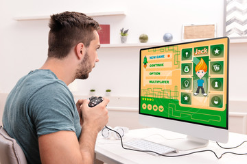 Wall Mural - Young man playing computer games at home