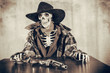 Old West Skeleton Revolver. Old west bandit outlaw skeleton at a poker table with a colt 45 pistol revolver edited in vintage film style.
