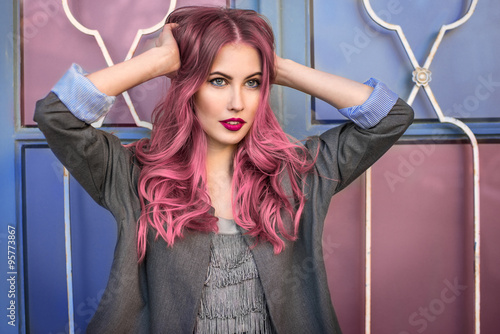 Plakat na papierze fotorealistycznym Piękny model moda hipster z kręcone włosy różowe pozowanie przed kolorowe ściany