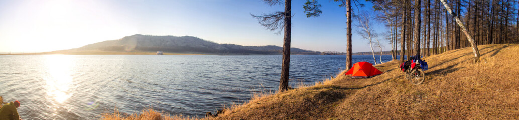 mountain lake with cycling tourist camp