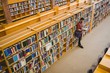 © WavebreakmediaMicro - Student reading a book from shelf in library