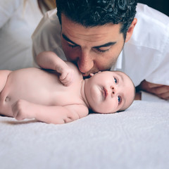 Sticker - Man kissing to peaceful newborn lying over bed